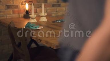 服务员提供晚餐桌上有预定的浪漫约会标志。 服务员准备晚餐的预定桌子